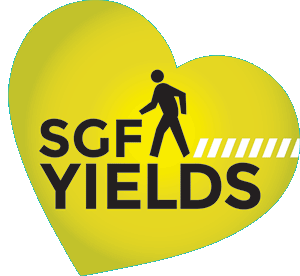 yellow tilted heart with pedestrian walker in it and text: s g f yields