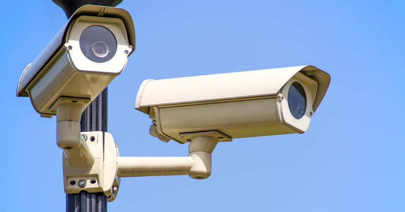 two security cameras mounted to a pole