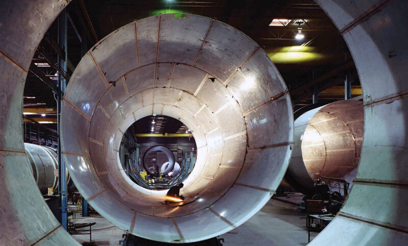 view inside large stainless steel tank with metalworker working inside